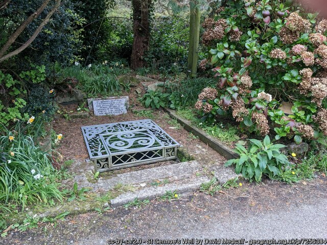A square stone-lined water-filled basin covered with a metal grille